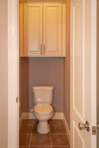 a white toilet sitting in a bathroom next to a window