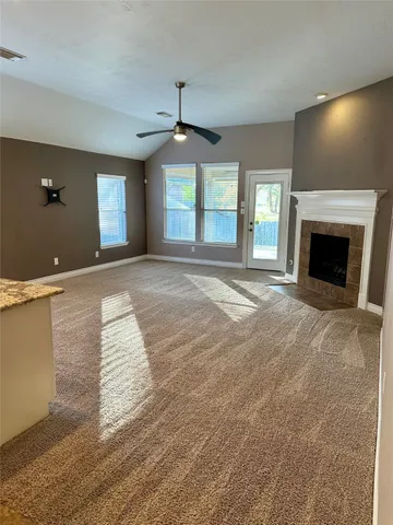a view of an empty room with window and fire place