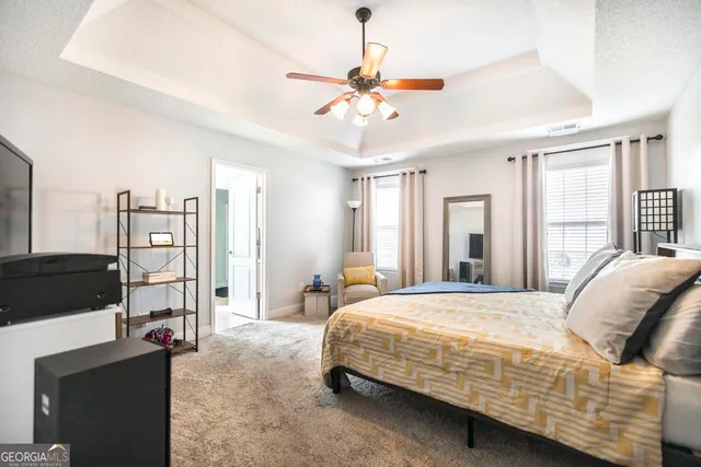 a bedroom with a bed a window and a flat screen television