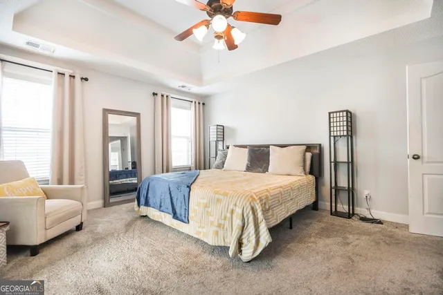 a spacious bedroom with a bed couch and window