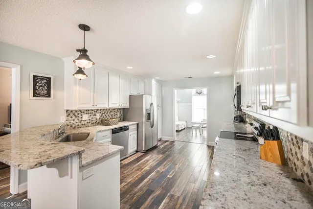 a kitchen with stainless steel appliances granite countertop a sink stove and refrigerator