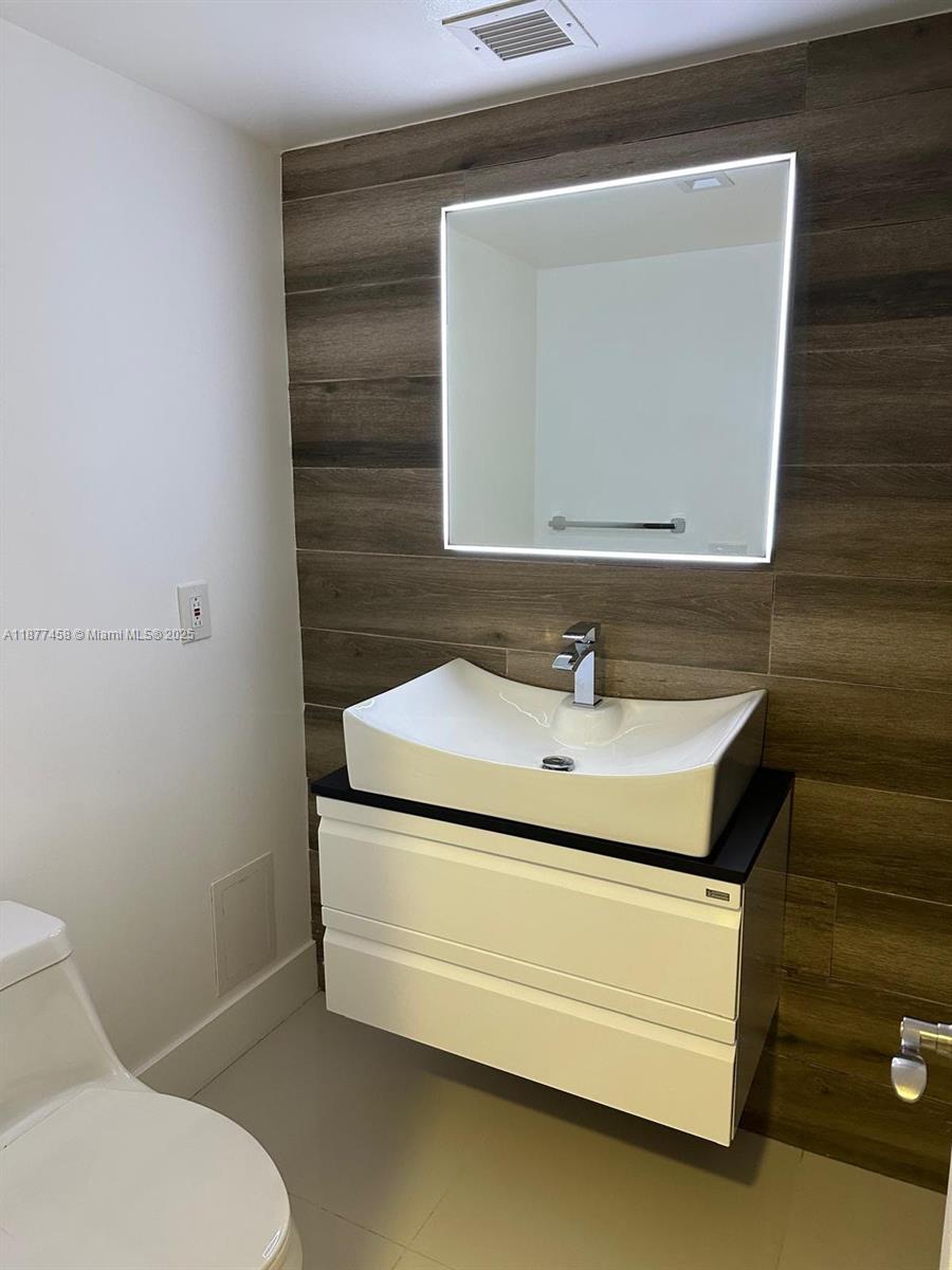 2801 Northeast 183rd Street, Unit 1909W Aventura, FL 33160 - Photo 8 of 17 a bathroom with a sink toilet and mirror