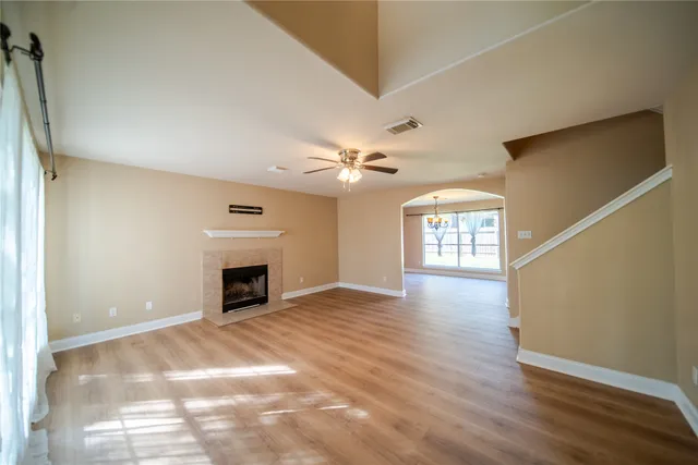 a view of an empty room with window and wooden floor