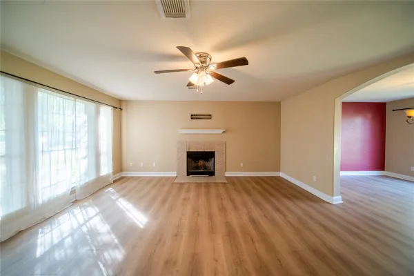 a view of an empty room with window and a fireplace