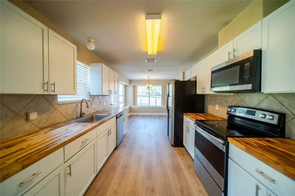 a kitchen with stainless steel appliances a stove sink microwave and cabinets