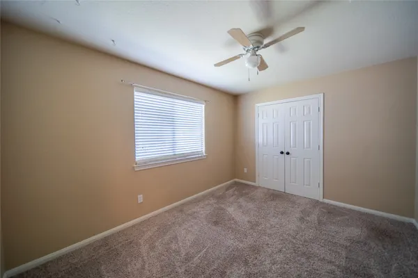 a view of an empty room with a ceiling fan