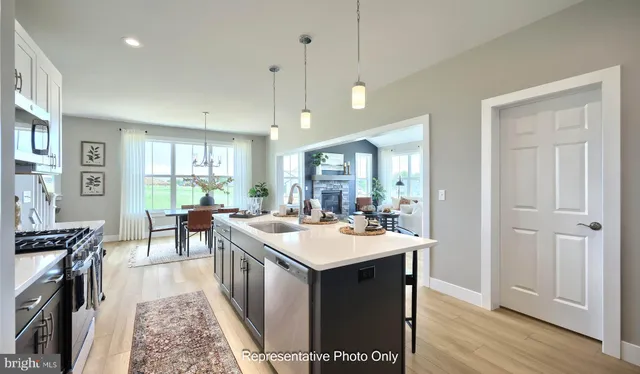 a kitchen with a stove a refrigerator a sink dishwasher with a dining table and chairs