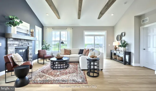 a living room with furniture large window and wooden floor