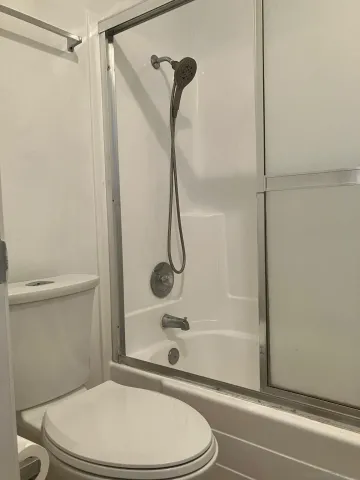 a bathroom with a toilet and a shower