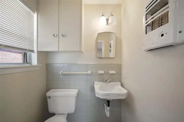 a bathroom with a toilet a sink and mirror