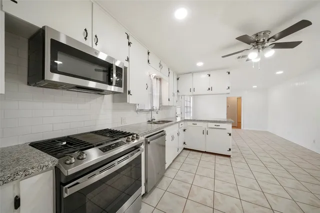 a kitchen with stainless steel appliances a sink a stove a microwave and cabinets