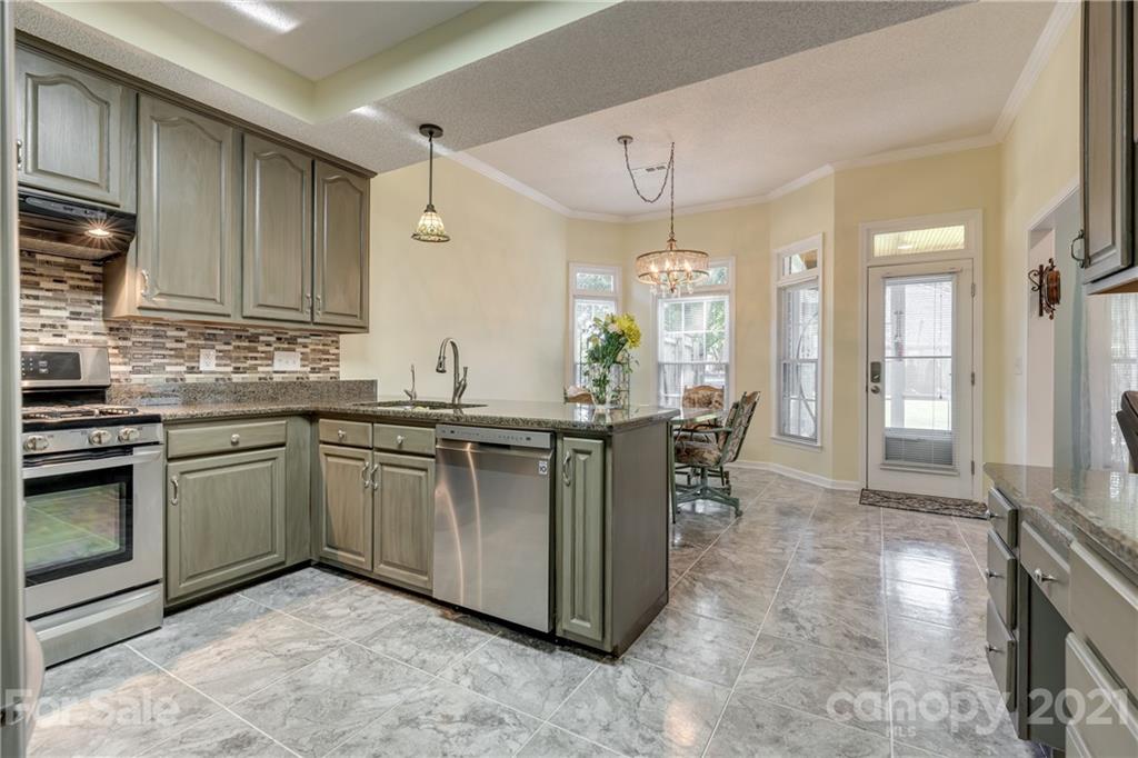 711 Monticello Drive Fort Mill, SC 29708 - Photo 12 of 45 a kitchen with granite countertop a sink stove and cabinets