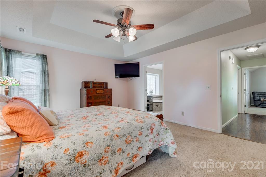 711 Monticello Drive Fort Mill, SC 29708 - Photo 20 of 45 a bedroom with a bed and a chandelier