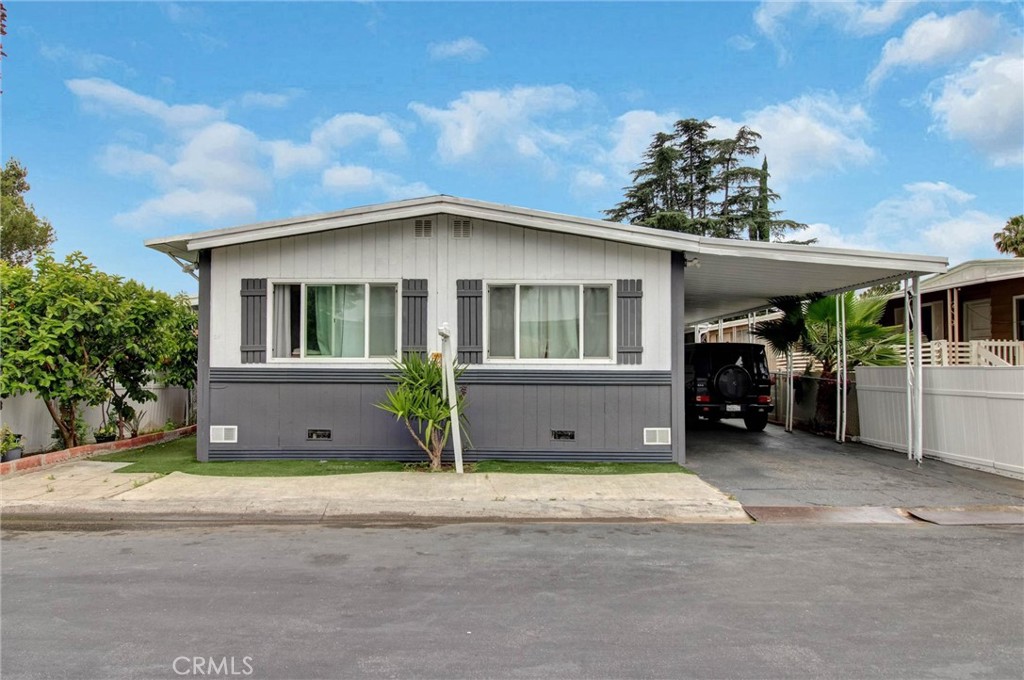 1025 South Riverside Avenue, Unit 26 Rialto, CA 92376 - Photo 2 of 27 a front view of a house with a garden and garage