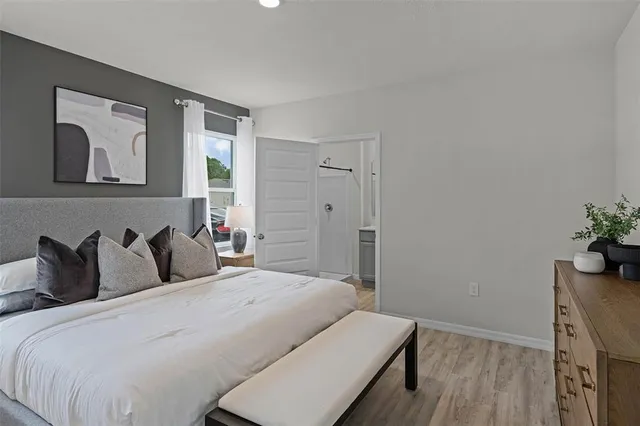 a bedroom with a bed and a potted plant