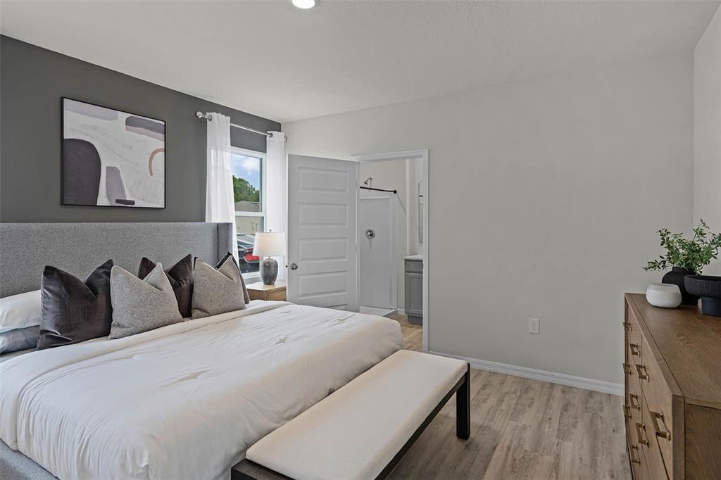 3421 Nettle Loop Tavares, FL 32778 - Photo 11 of 30 a bedroom with a bed and a potted plant