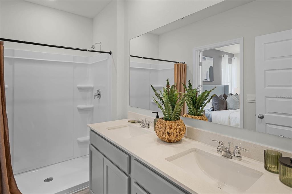 3421 Nettle Loop Tavares, FL 32778 - Photo 15 of 30 a bathroom with a granite countertop sink a mirror and a shower