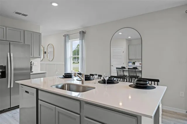 a kitchen with a sink a refrigerator and cabinets
