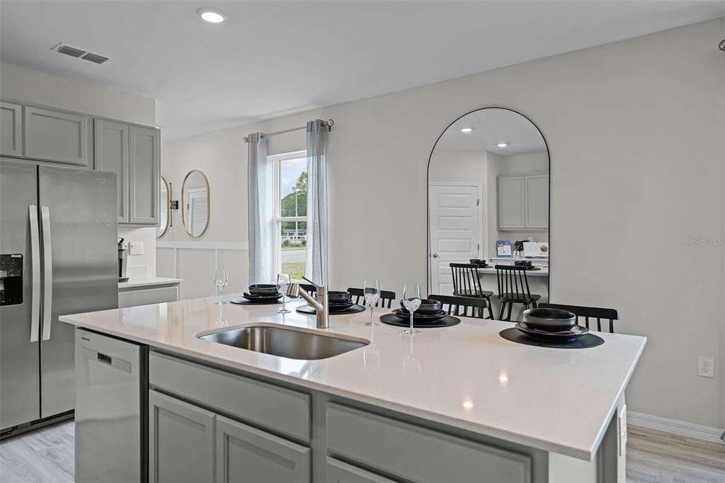 3421 Nettle Loop Tavares, FL 32778 - Photo 8 of 30 a kitchen with a sink a refrigerator and cabinets