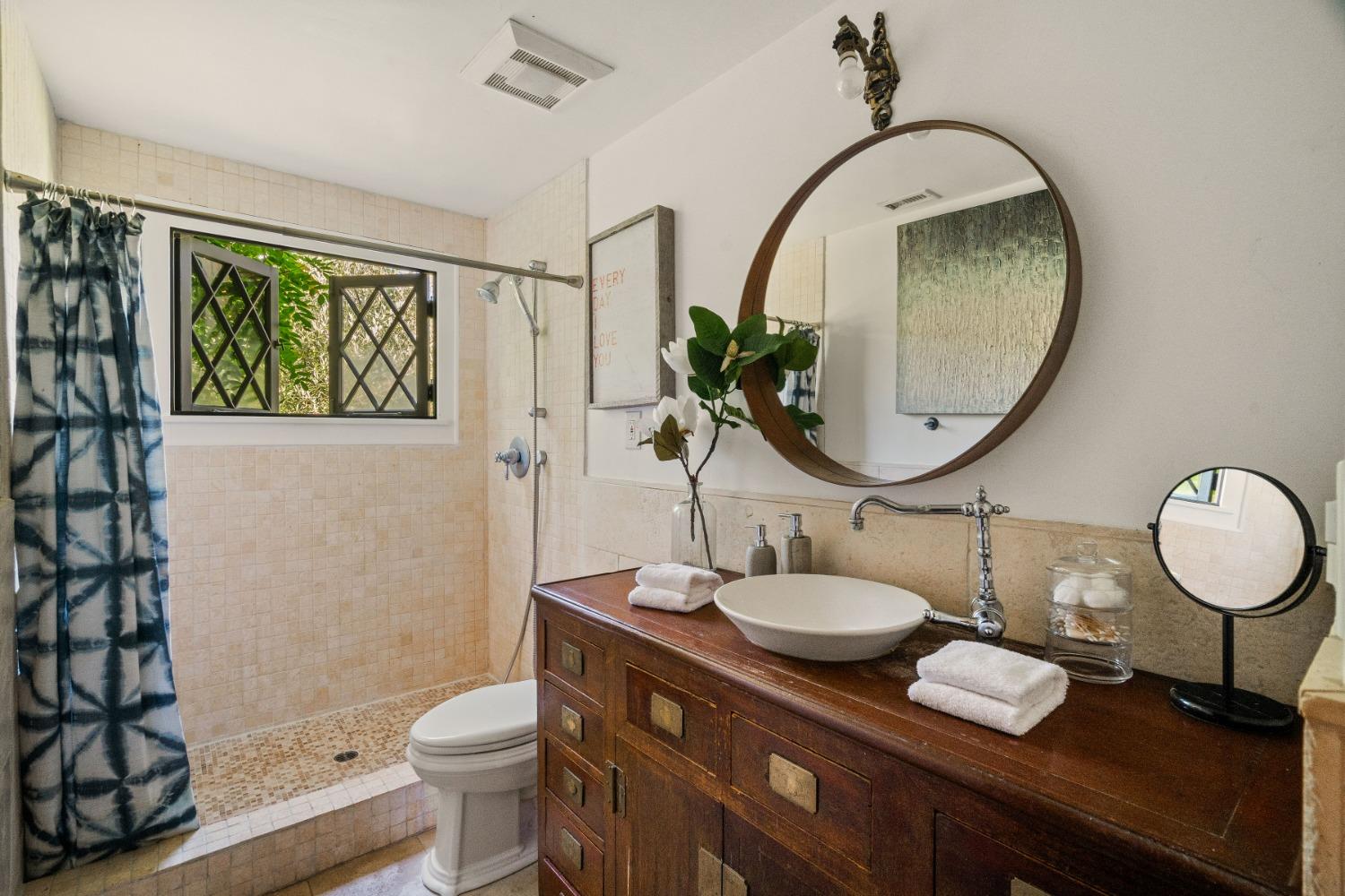 1001 Foothill Road Ojai, CA 93023 - Photo 35 of 50 a bathroom with a granite countertop toilet a sink and a mirror