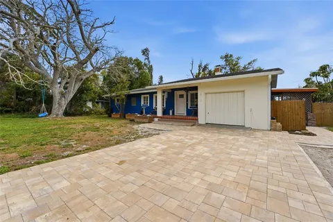 a view of a house with a yard and potted plants