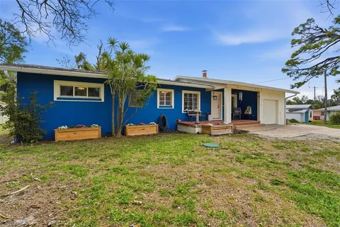 a view of a house with a backyard and a tree