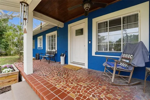 a balcony with table and chairs and a barbeque