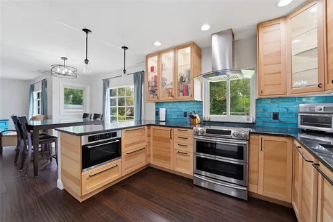 a kitchen with stainless steel appliances kitchen island granite countertop a stove a sink and a refrigerator