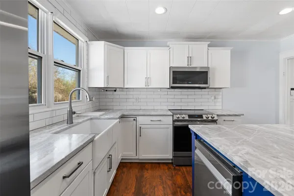 a kitchen with granite countertop a sink stove and cabinets