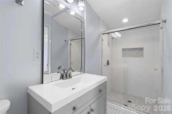 a bathroom with a shower sink vanity and mirror