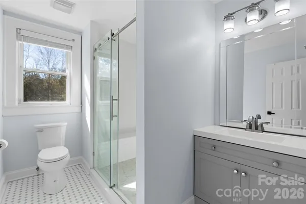 a bathroom with a sink a toilet and shower