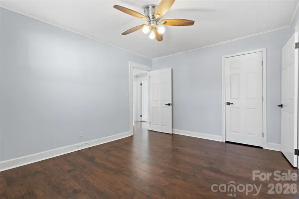 an empty room with wooden floor and ceiling fan