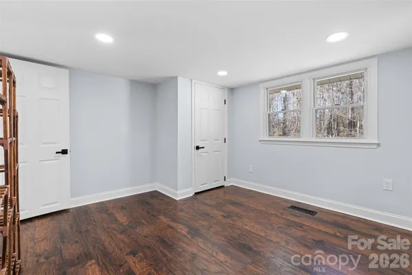 a view of empty room with wooden floor and window