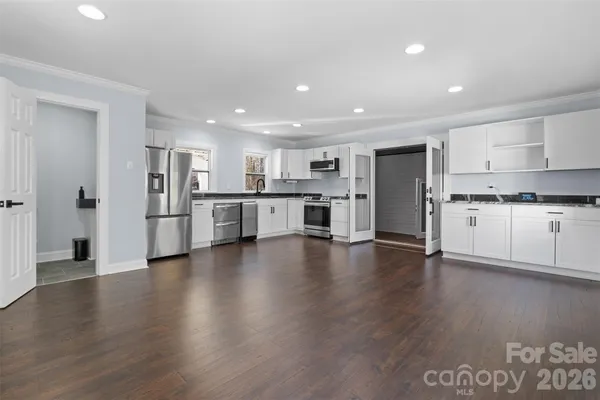a view of kitchen with refrigerator sink and cabinets