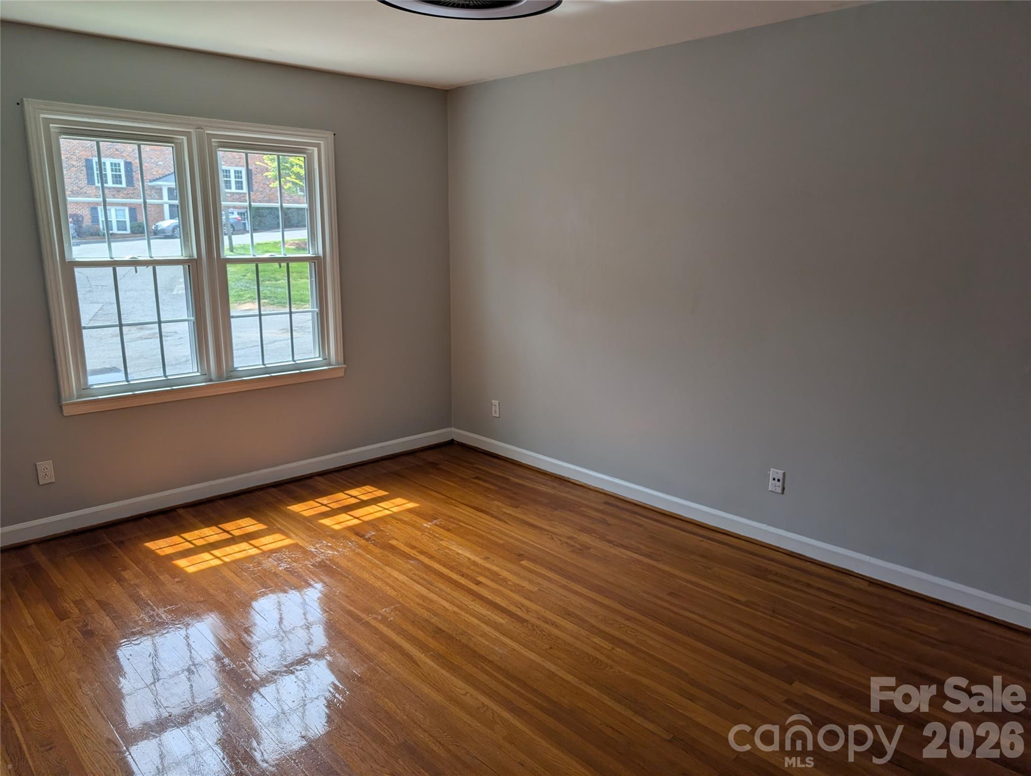 916 McAlway Road, Unit D Charlotte, NC 28211 - Photo 4 of 12 a view of empty room with wooden floor and fan