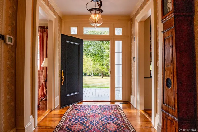 a view of a hallway to a livingroom with furniture and front door
