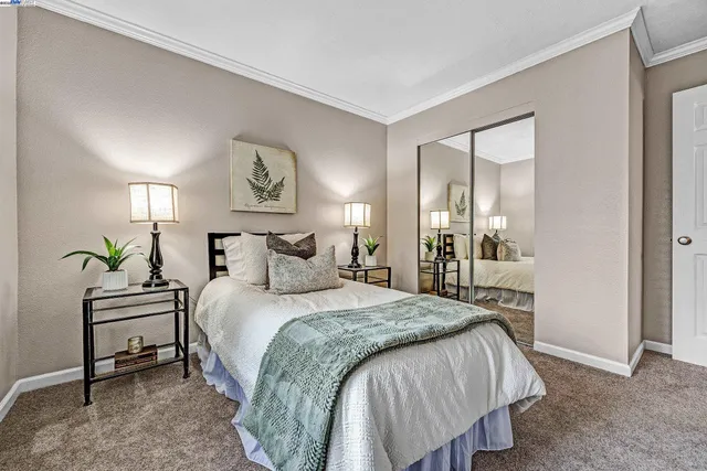 a spacious bedroom with a bed table and a painting