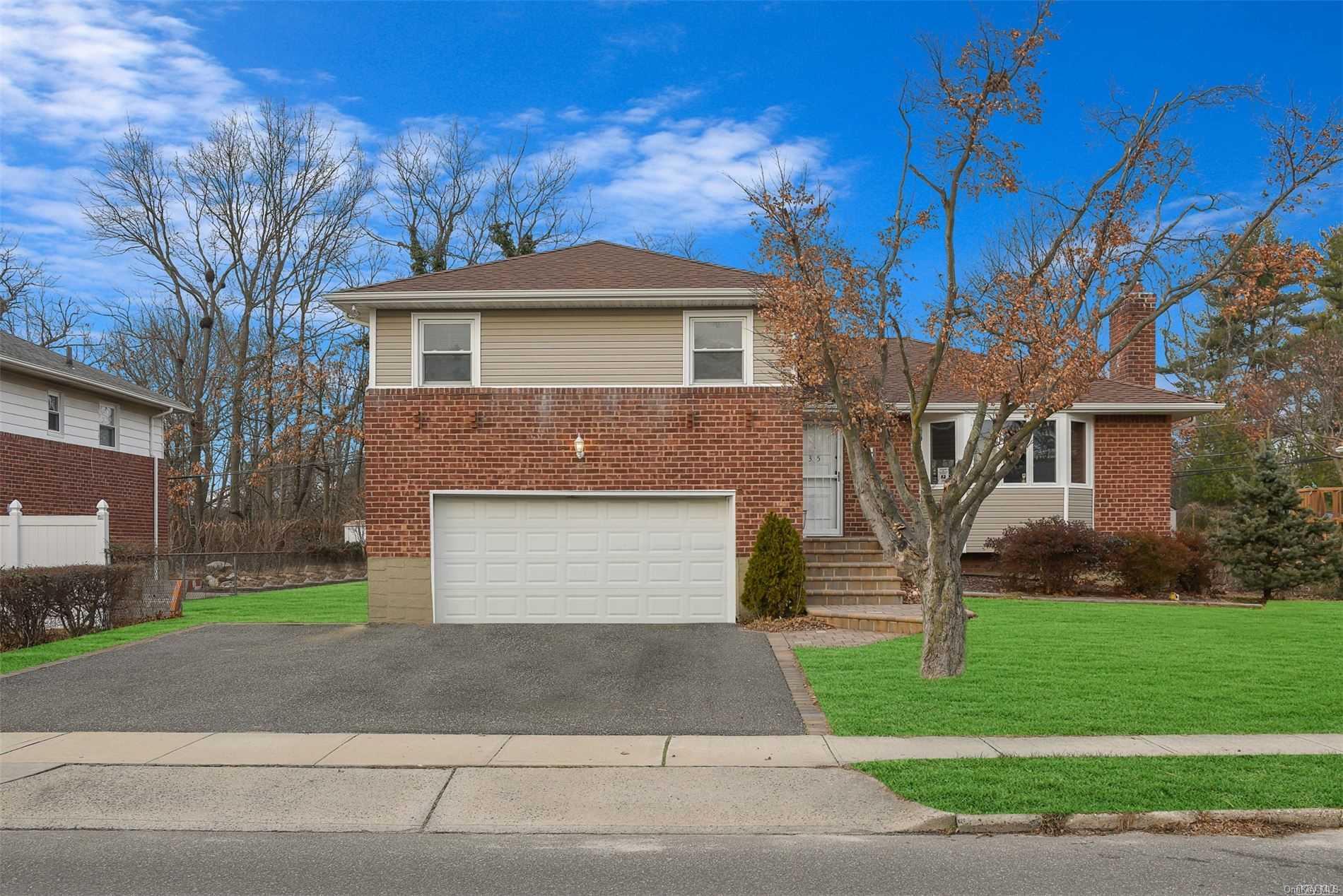 35 Hicks Avenue Syosset, NY 11791 - Photo 1 of 1 a front view of a house with a yard and garage