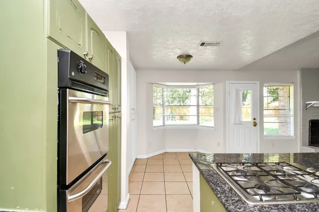 a kitchen with granite countertop a stove and a refrigerator