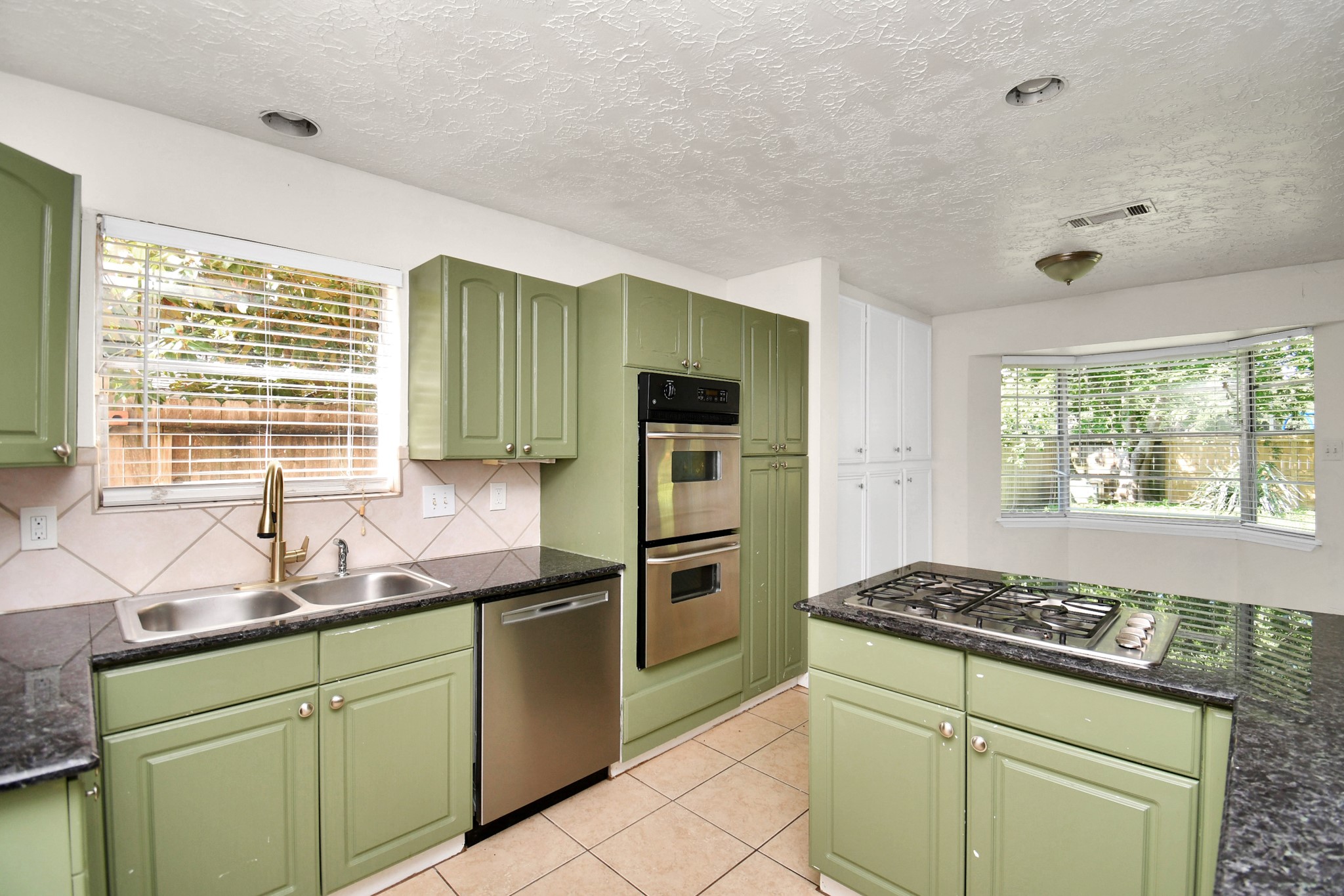 18023 Woodgum Drive Spring, TX 77388 - Photo 18 of 38 a kitchen with granite countertop a sink stainless steel appliances and window