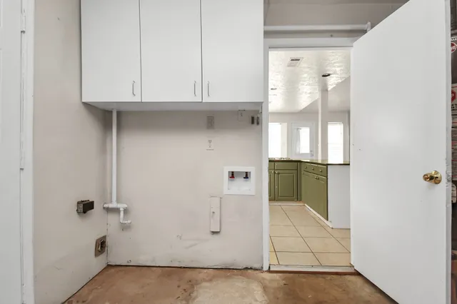 a view of a kitchen with white cabinets and wooden floor