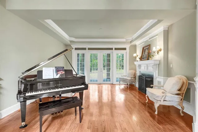 a dining room with furniture large windows and a chandelier