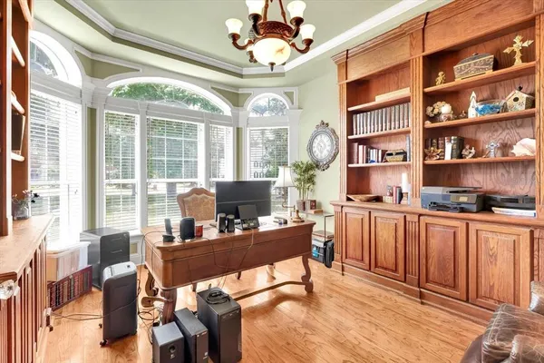 a view of a dining room with furniture a chandelier and large windows