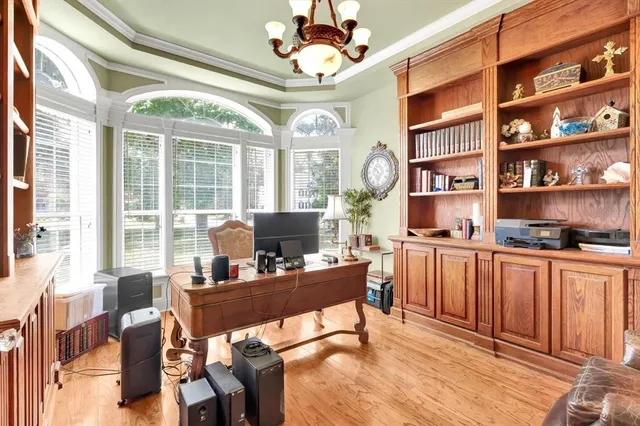 a view of a dining room with furniture a chandelier and large windows