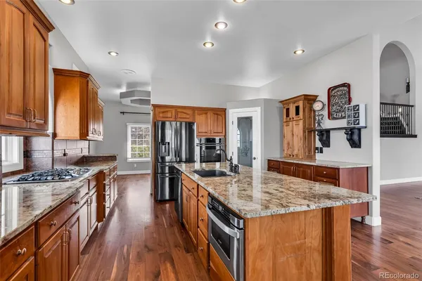 a kitchen with granite countertop a stove and cabinets