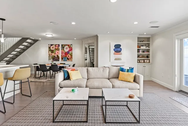 a living room with furniture a rug and a wall painting