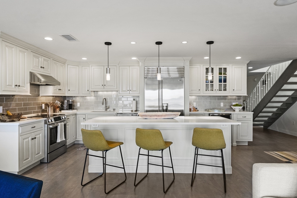 64 Cliffside Drive, Unit 64 Plymouth, MA 02360 - Photo 5 of 42 a kitchen with kitchen island a stove a table and chairs in it