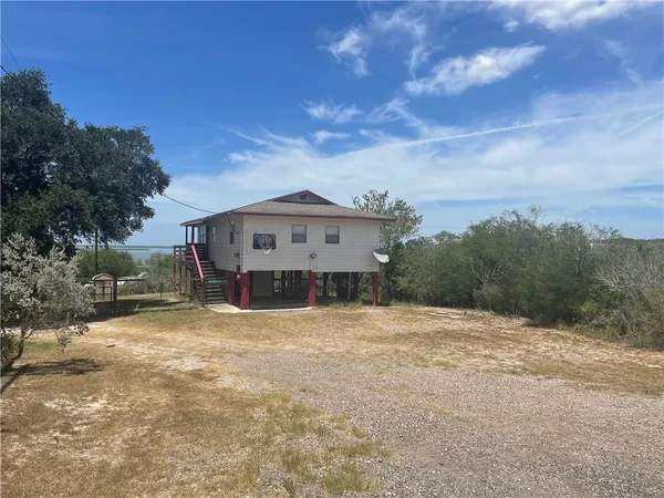 a view of a house with a large tree in front of it