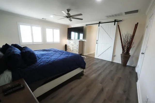 a spacious bedroom with a bed window and a ceiling fan