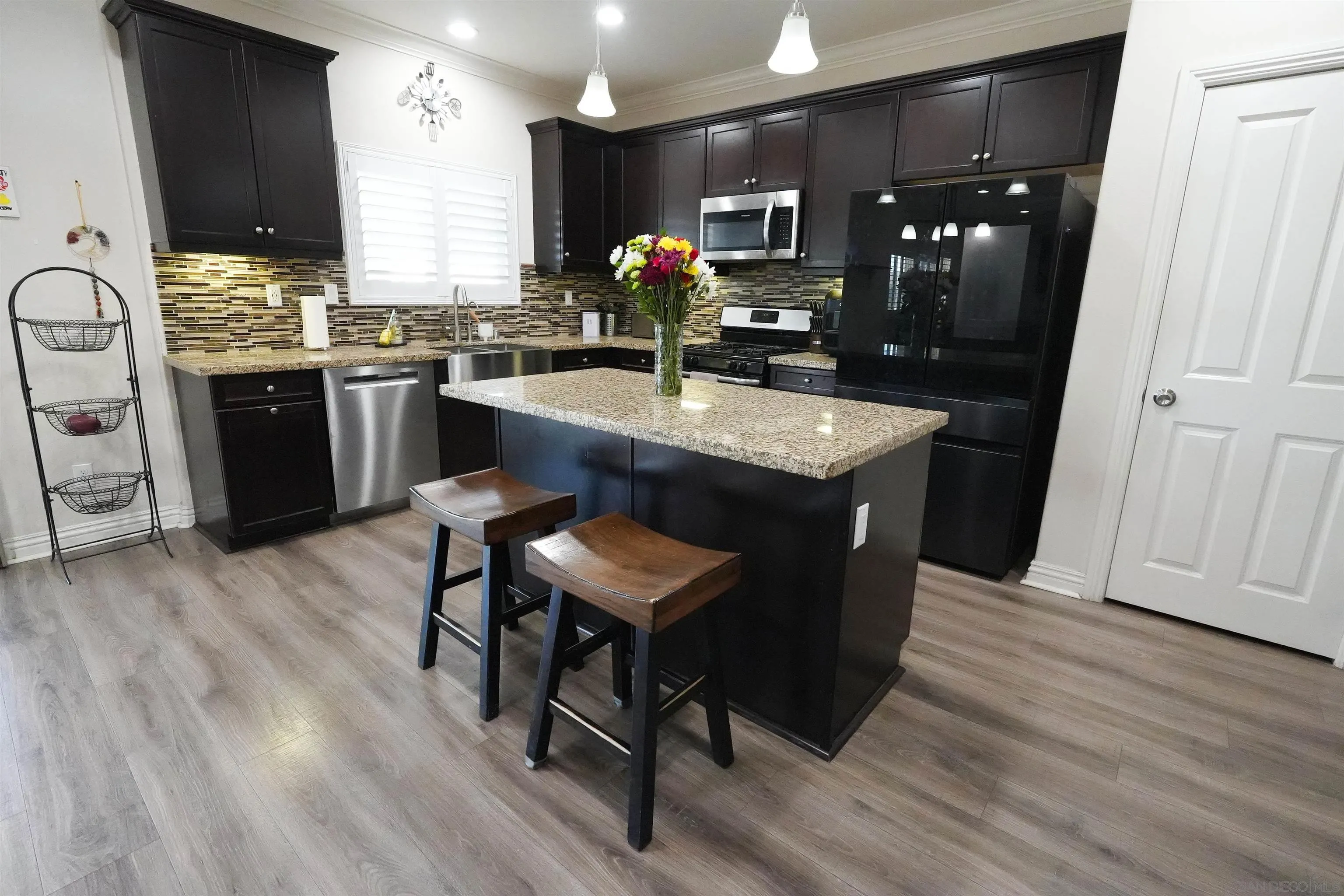 3326 Crowfoot Road San Bernardino, CA 92407 - Photo 2 of 20 a kitchen with stainless steel appliances granite countertop a sink dishwasher a stove a refrigerator and island with wooden floor